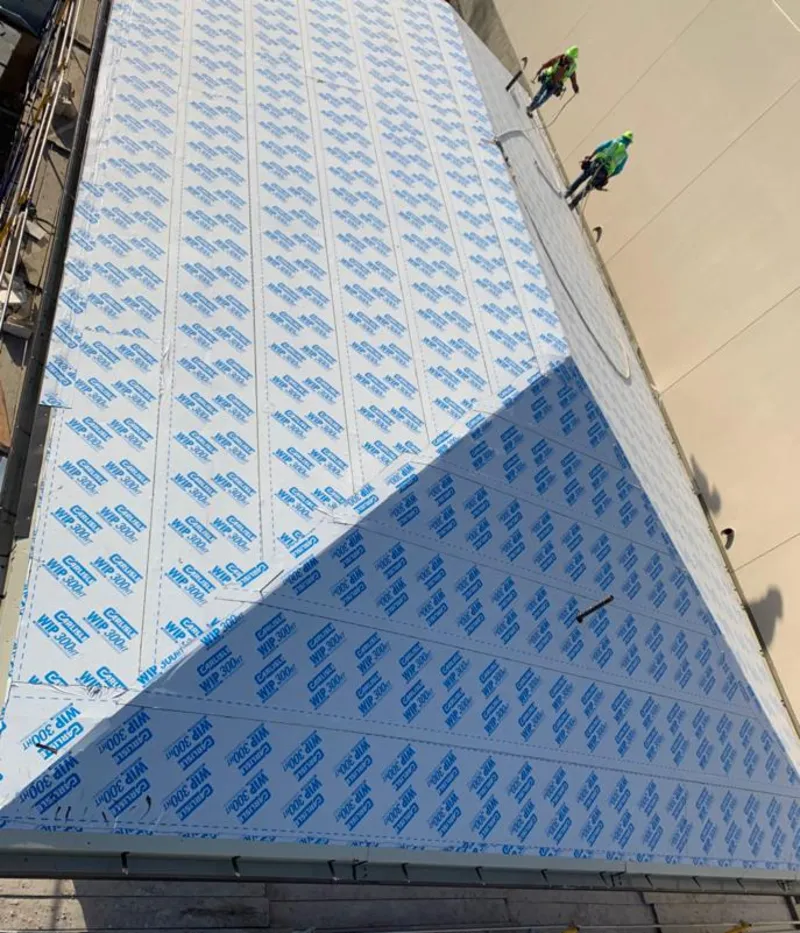 Professional roofers installing underlayment on a metal roof in Norwalk